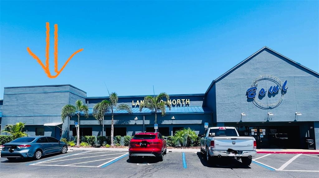 The exterior of a commercial building features a blue facade, a parking lot, and palm trees — 6935 RIDGE ROAD, PORT RICHEY, FL