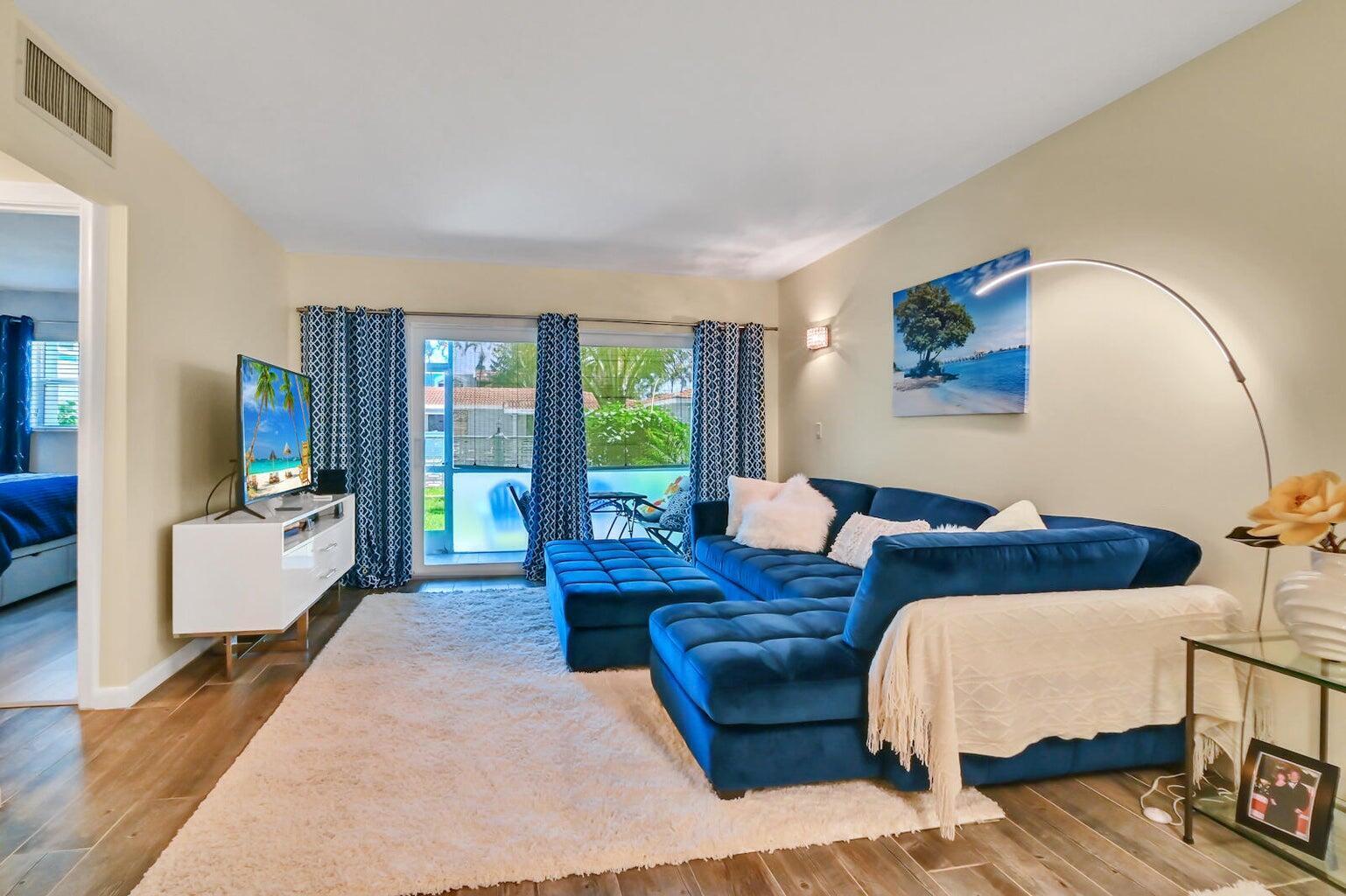 A living room features a blue velvet sectional, white rug, and a sliding glass door — 1432 S Lakeside Drive # 2, FL 33460, FL