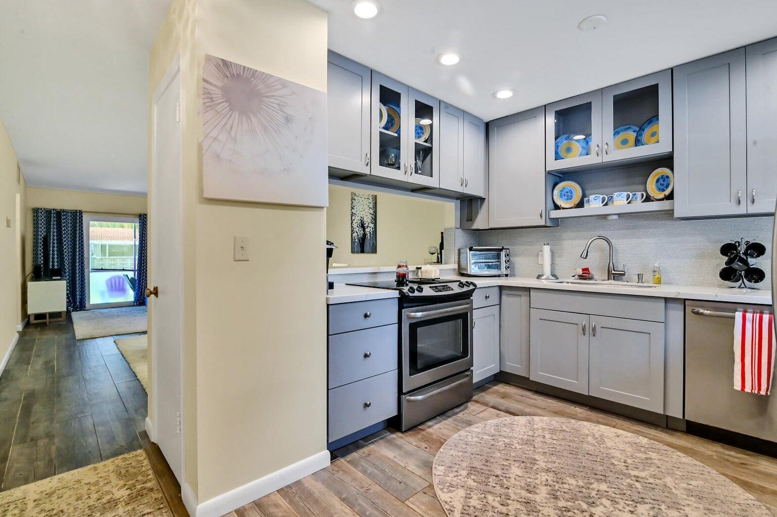 A kitchen with gray cabinets, stainless steel appliances, and a round rug on wood flooring — 1432 S Lakeside Drive # 2, FL 33460, FL