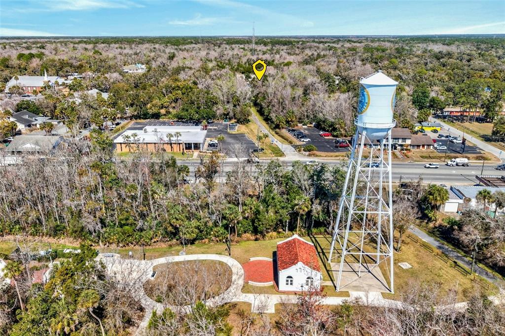 An aerial view shows a water tower, a small historic building, and surrounding parking lots — 110 NE CRYSTAL STREET, CRYSTAL RIVER, FL