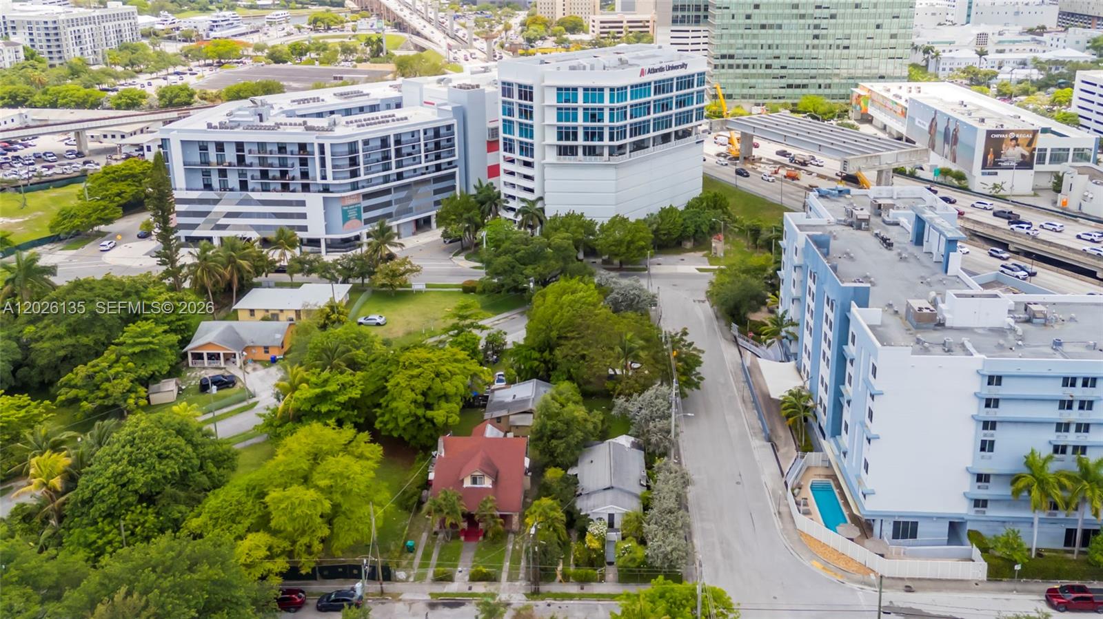 An aerial view shows a residential street with houses nestled between large modern apartment buildings — 1246 NW 9th Ave, Miami FL 33136, MIAMI, FL