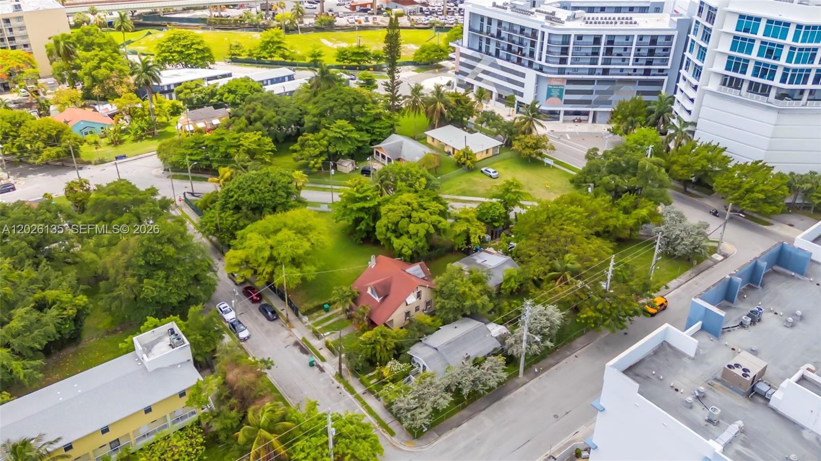 An aerial view shows several houses surrounded by trees and nearby multi-story apartment buildings — 1246 NW 9th Ave, Miami FL 33136, MIAMI, FL