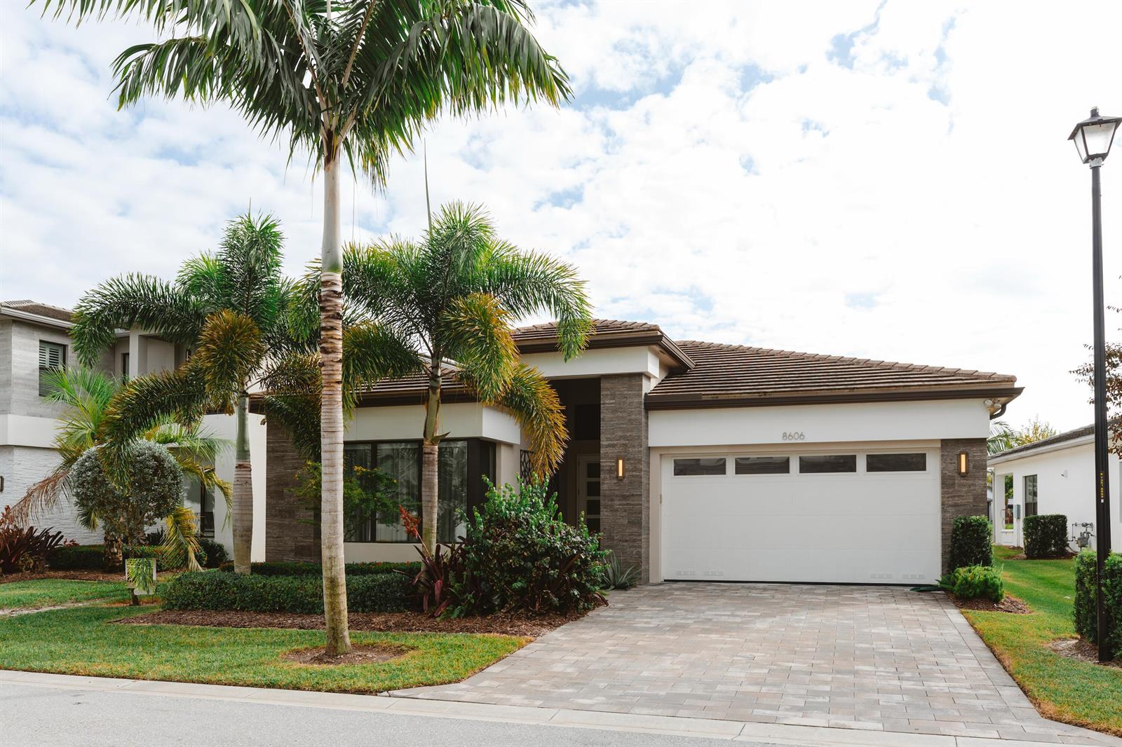 A single-story house with a white garage, stone accents, and palm trees in the front yard — 8606 Tower Bridge Court, Boca Raton FL 33496, BOCA RATON, FL