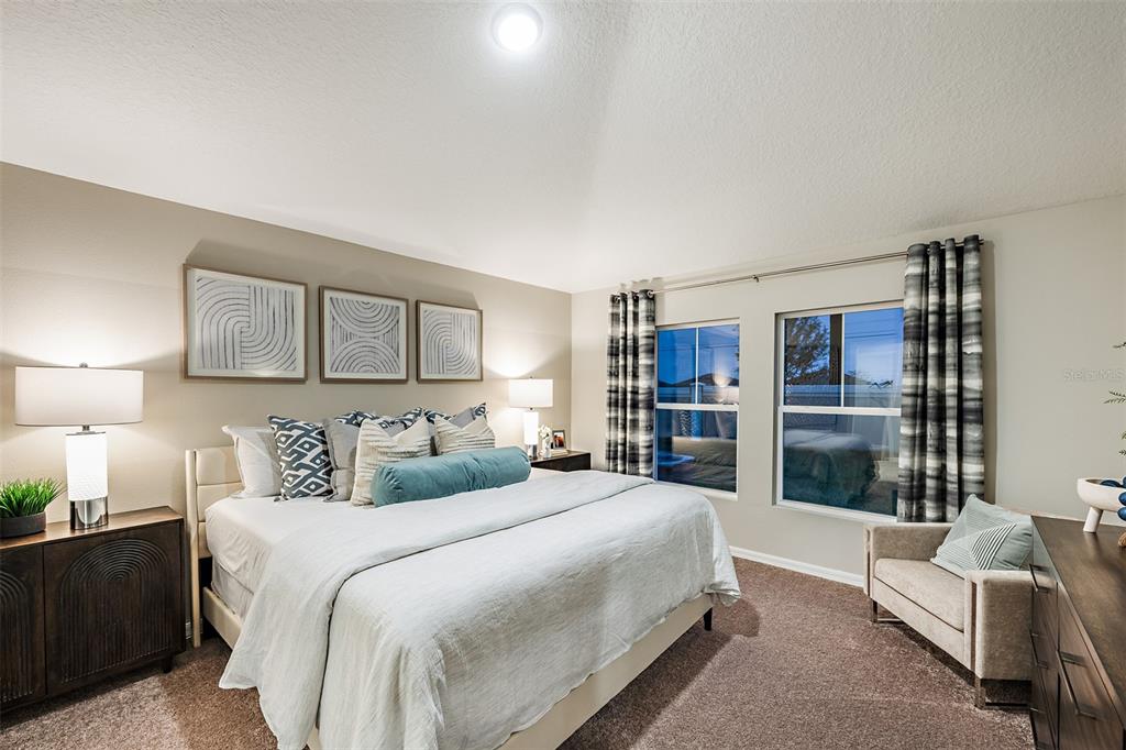 A bedroom features a king bed, two nightstands, a chair, and two windows with curtains — 5828 HEAVEN ROAD, HAINES CITY, FL