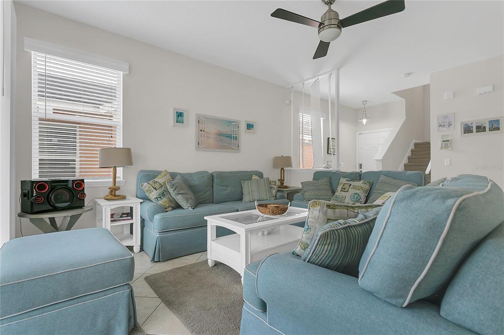 A living room features light blue sofas, a white coffee table, and a ceiling fan — 178 HAMMOCK COURT, DAVENPORT, FL