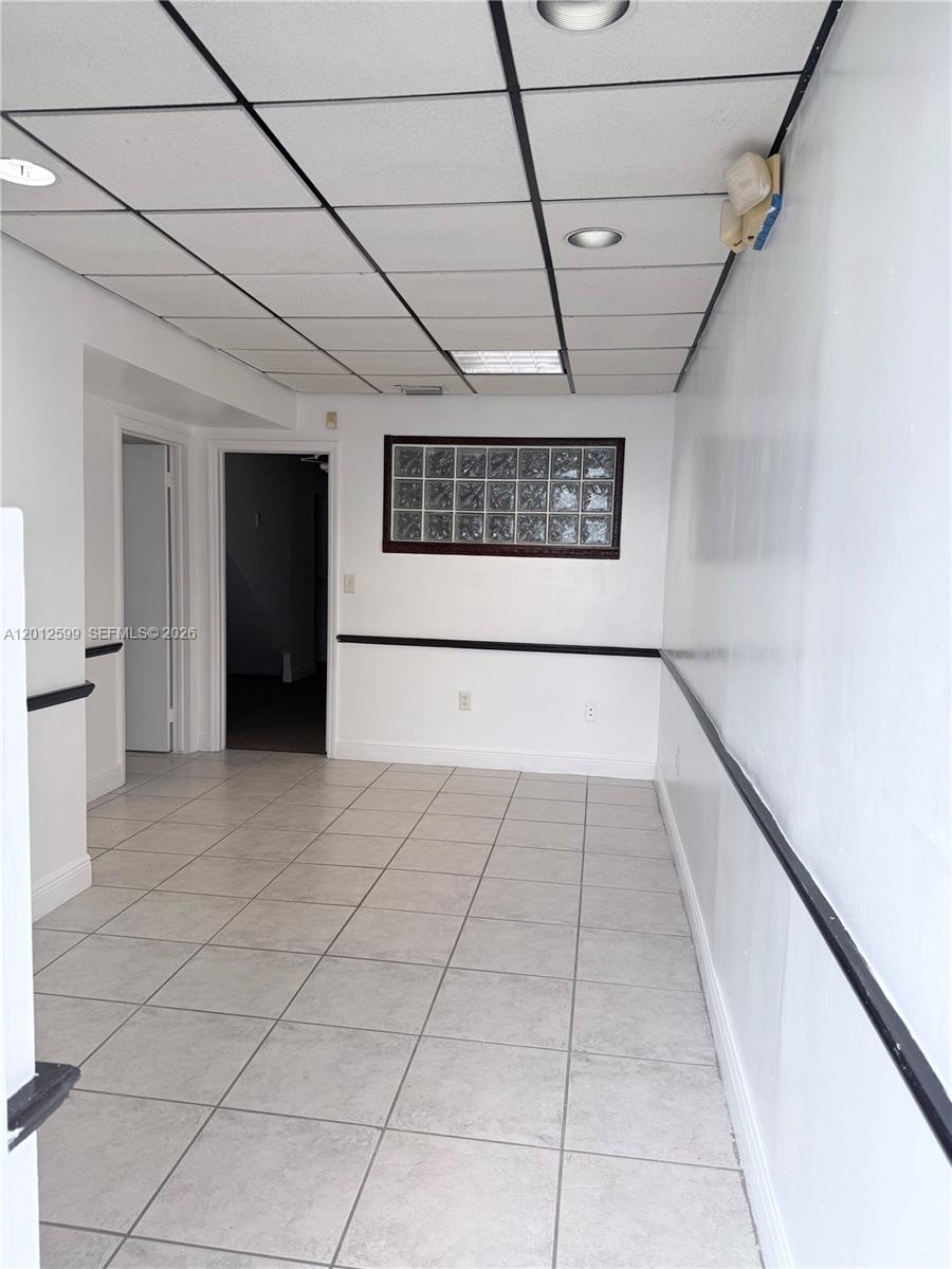 A room with a drop ceiling, tiled floor, and a glass block window — 12311 SW 133rd Ct # 23, Miami FL 33186, MIAMI, FL