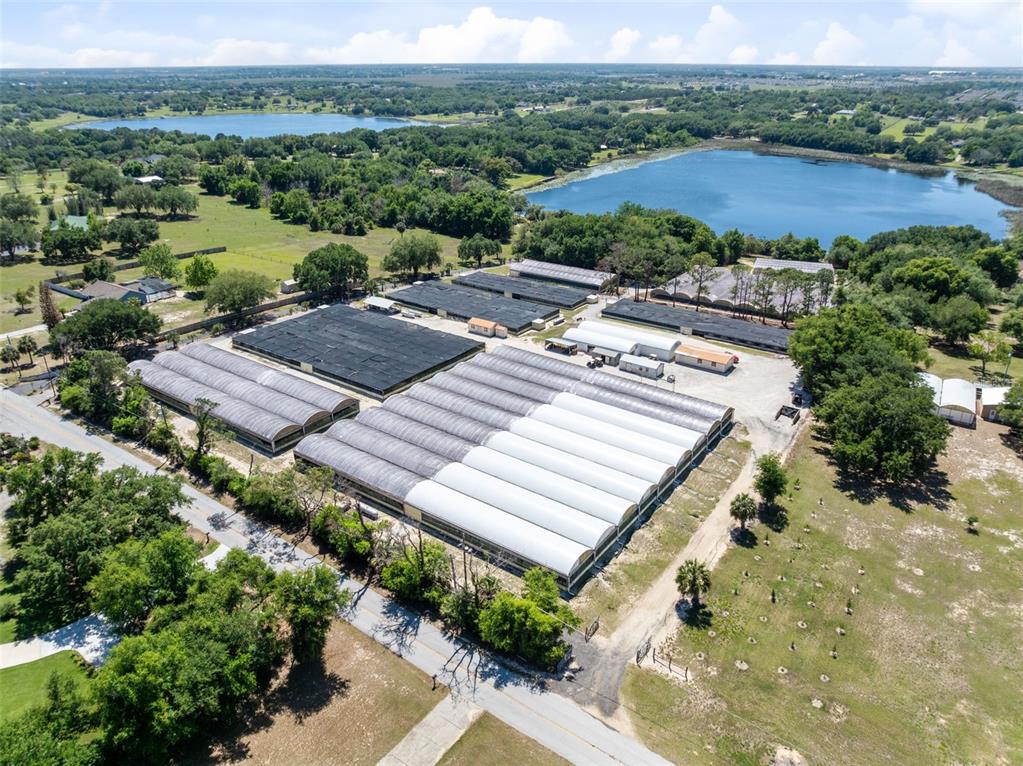 An aerial view shows a large agricultural nursery with multiple greenhouses and shade structures — 18021 E APSHAWA ROAD, MINNEOLA, FL