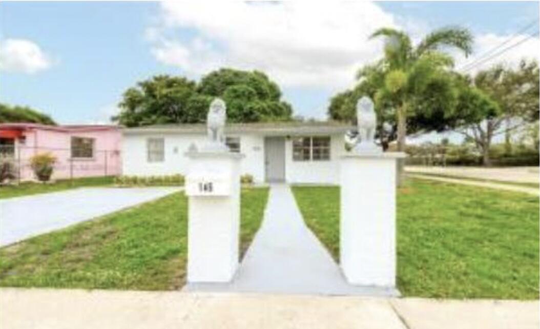 A white single-story house features two lion statues atop pillars flanking the front walkway — 145 SW 13th Avenue, Delray Beach FL 33444, DELRAY BEACH, FL
