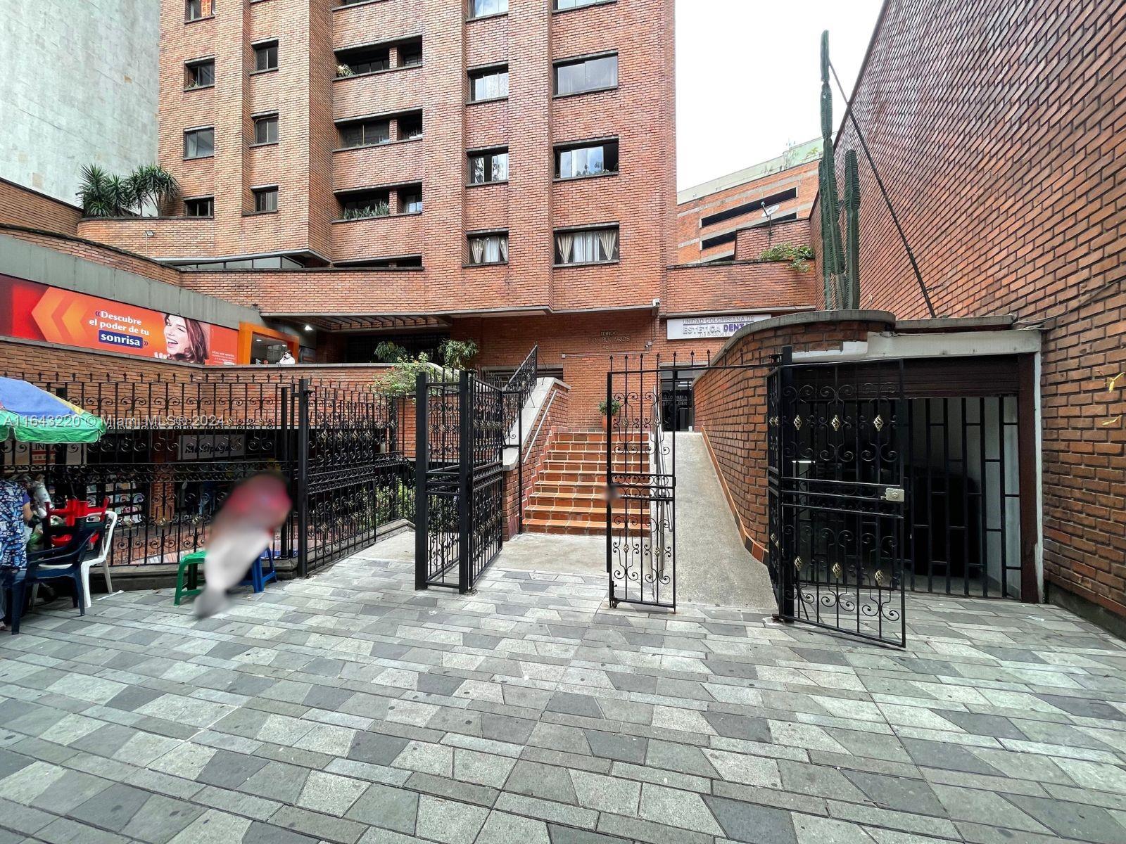 An exterior view of a brick building with a gated entrance and stone-paved courtyard — Calle 52 45-44 # 2001, CO, CO
