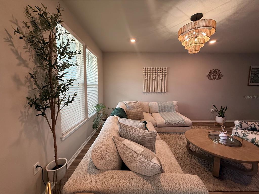 A living room features a large sectional sofa, a round coffee table, and a chandelier — 14271 LANIKAI BEACH DRIVE, ORLANDO, FL