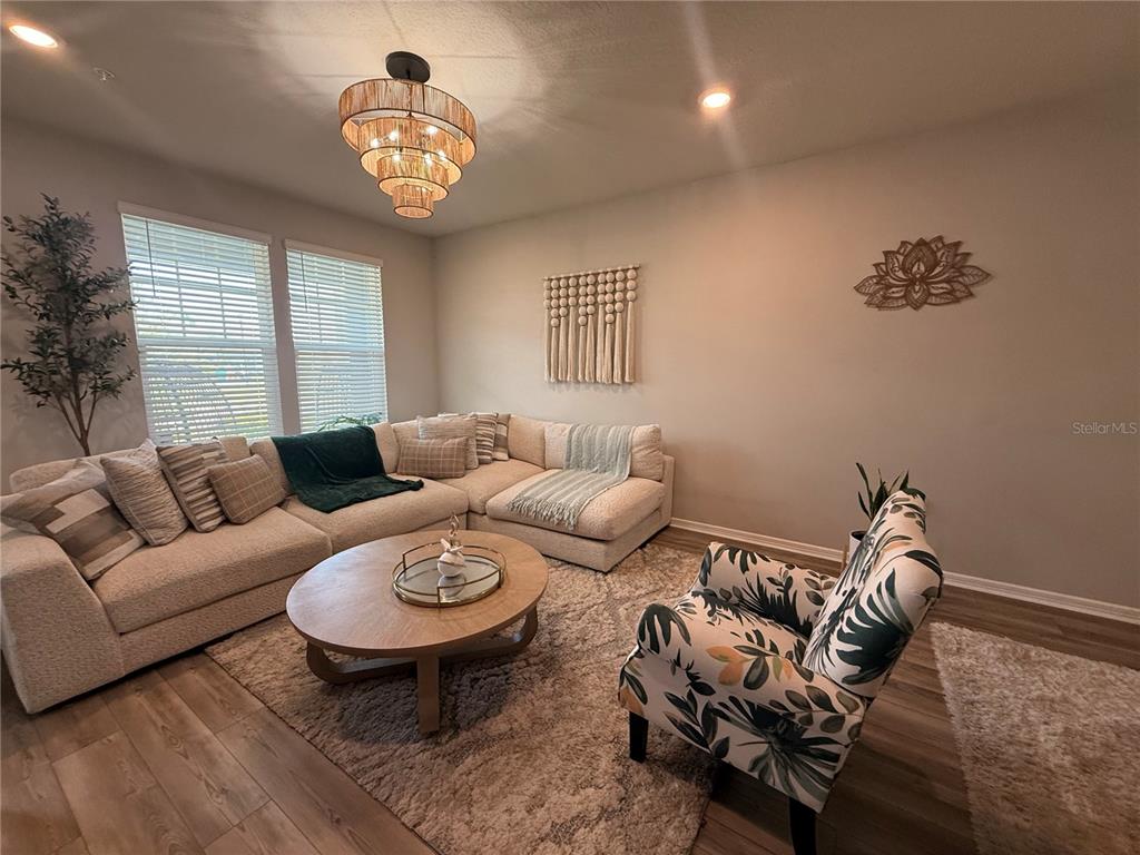 A living room features a sectional sofa, a round coffee table, and a patterned armchair — 14271 LANIKAI BEACH DRIVE, ORLANDO, FL