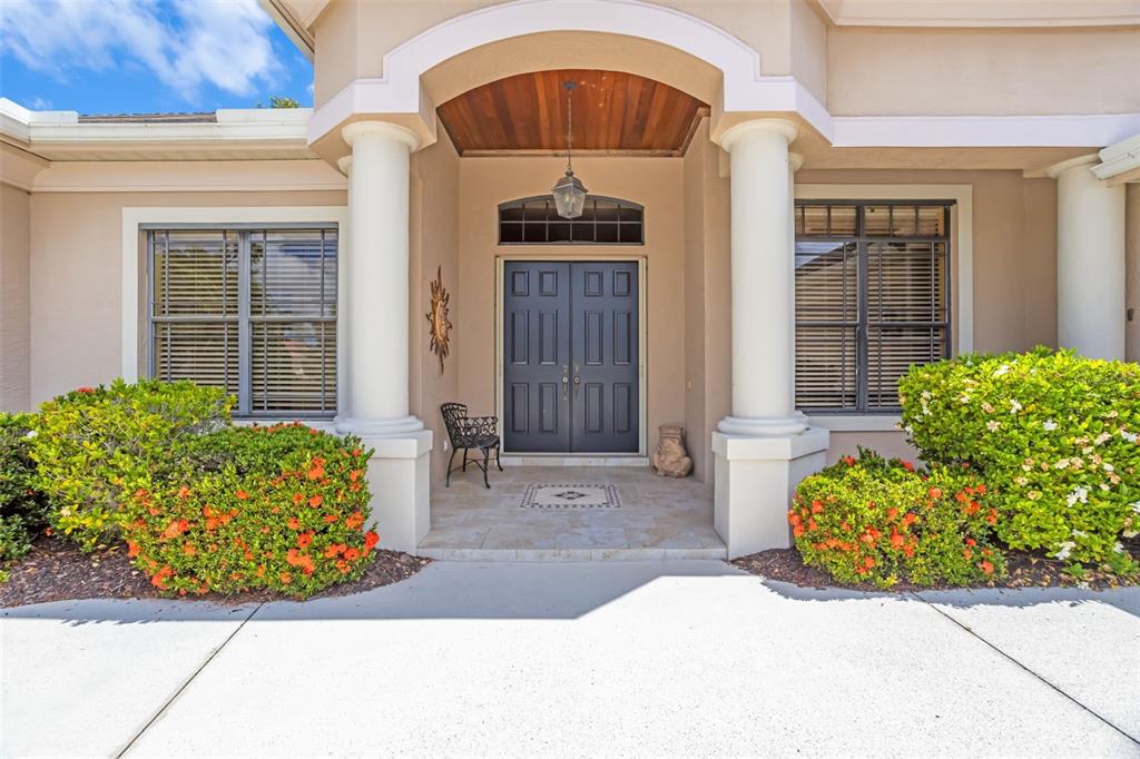 The front entrance of a house features a double door, two columns, and landscaped bushes — 2339 LITTLE COUNTRY ROAD, PARRISH, FL