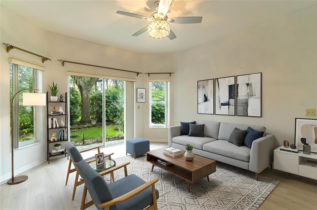 A living room features a gray sofa, two blue chairs, a coffee table, and sliding doors — 157 SAND PIPER DRIVE, KISSIMMEE, FL