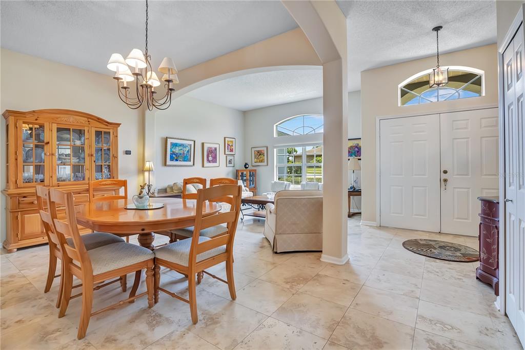 A dining area with a wooden table and hutch opens into a living room with tile floors — 1193 WINTERVILLE STREET, DELTONA, FL