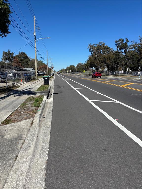 A paved road with a bike lane runs alongside a sidewalk and utility poles — 1630 S RIO GRANDE AVENUE, ORLANDO, FL