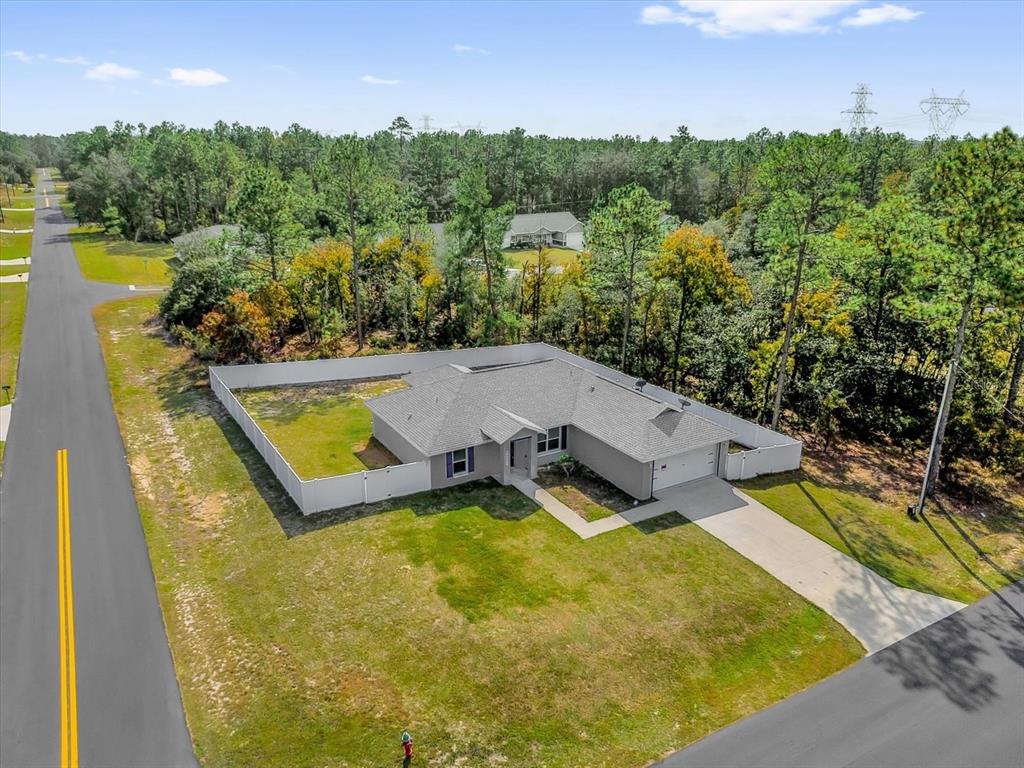 An aerial view of a single-story house with a fenced yard and a concrete driveway — 14923 SW 66TH AVENUE ROAD, OCALA, FL
