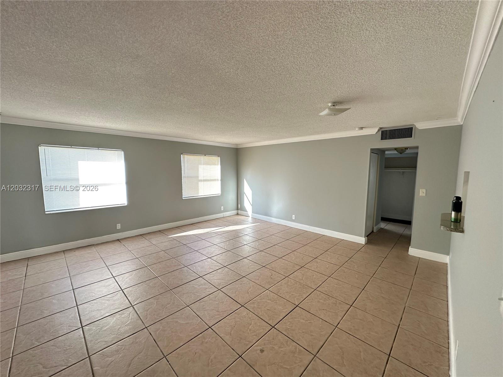 An empty room features light gray walls, beige tile flooring, and two windows with blinds — 2008 JACKSON ST # 7, Hollywood FL 33020, HOLLYWOOD, FL