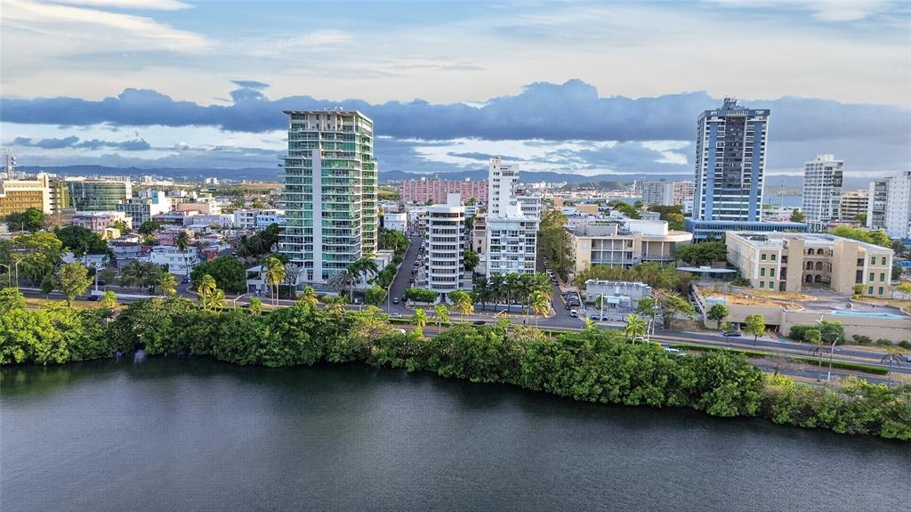 An aerial view shows a coastal city skyline with high-rise buildings and lush green trees — 501 ELISA COLBERG, MIRAMAR Apt 4-E, SAN JUAN, PR