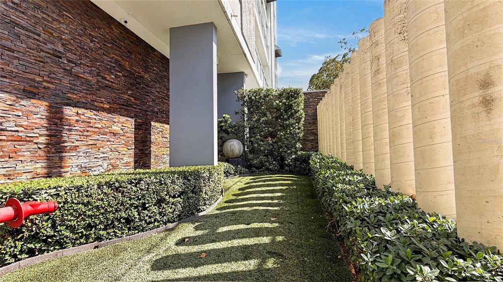 A stone wall and a row of concrete pillars flank a narrow, grassy walkway — 501 ELISA COLBERG, MIRAMAR Apt 4-E, SAN JUAN, PR