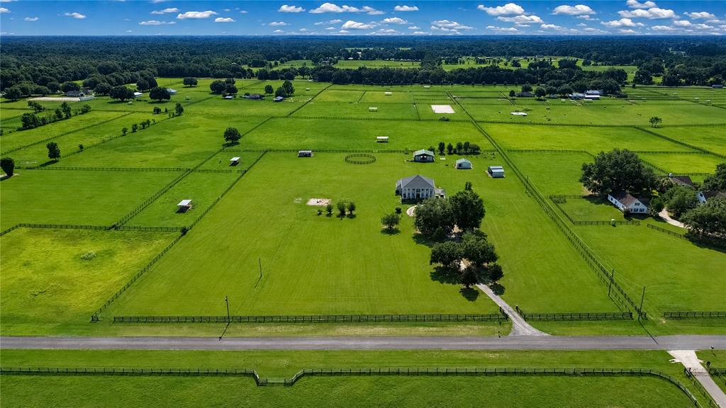 An aerial view shows a large house surrounded by fenced pastures and scattered trees — 12345 NE 14TH AVENUE, ANTHONY, FL