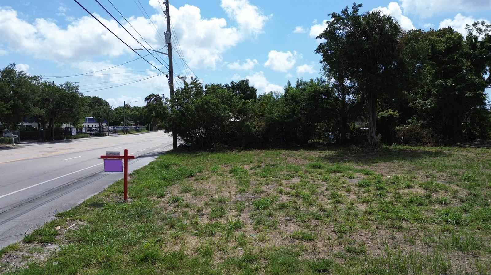A vacant grassy lot sits next to a paved road with a real estate sign — 2944 Westgate Avenue, West Palm Beach FL 33409, WEST PALM BEACH, FL
