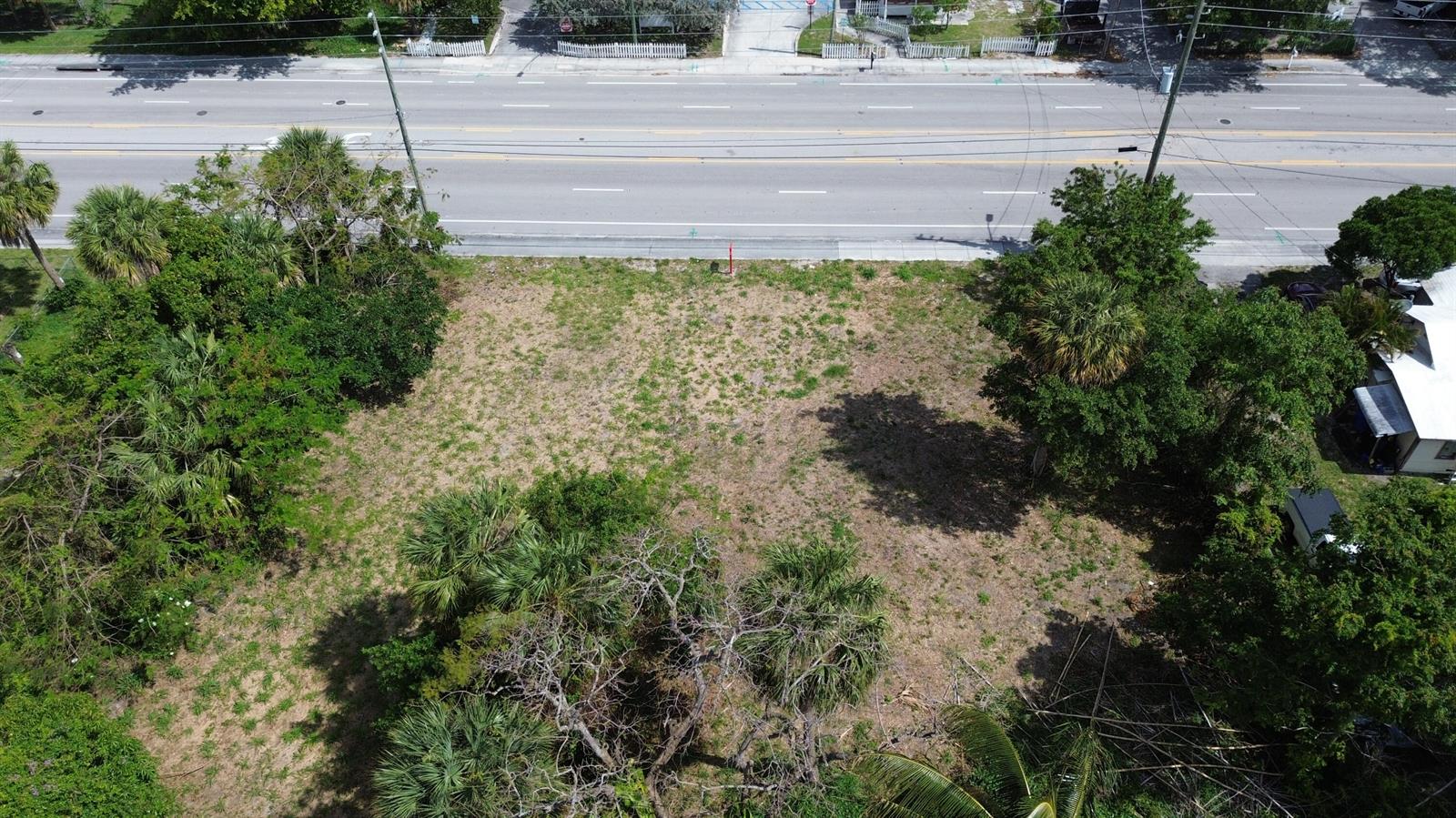 An aerial view shows a vacant, grassy lot situated between trees and a paved road — 2944 Westgate Avenue, West Palm Beach FL 33409, WEST PALM BEACH, FL