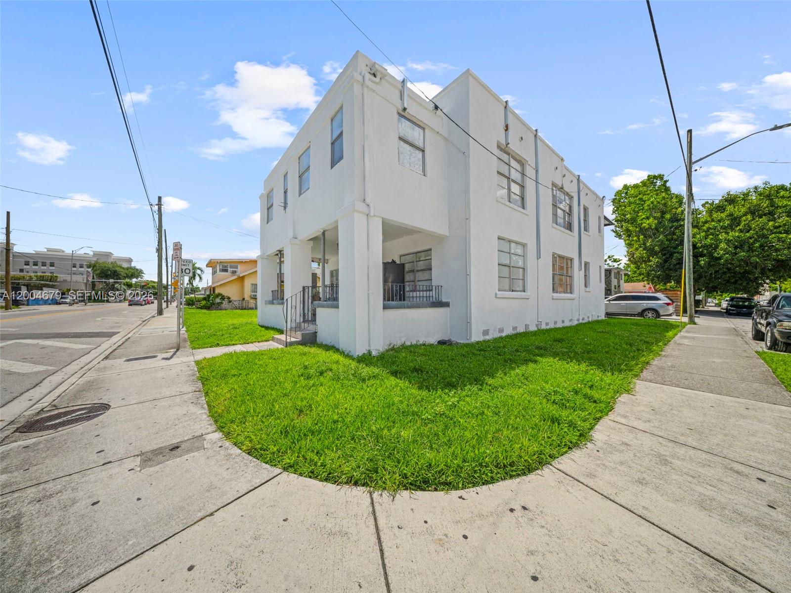 A two-story white stucco apartment building sits on a corner lot with a grassy lawn — 500 SW 8th AVE, Miami FL 33130, MIAMI, FL