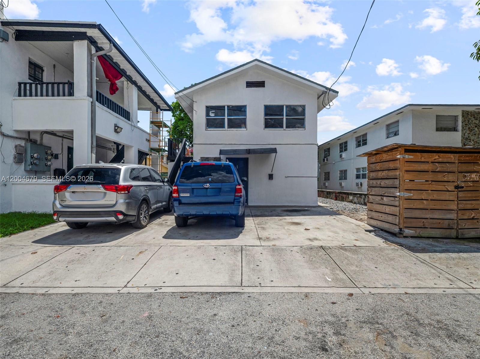 A two-story white building sits between two apartment complexes with two cars parked in front — 500 SW 8th AVE, Miami FL 33130, MIAMI, FL
