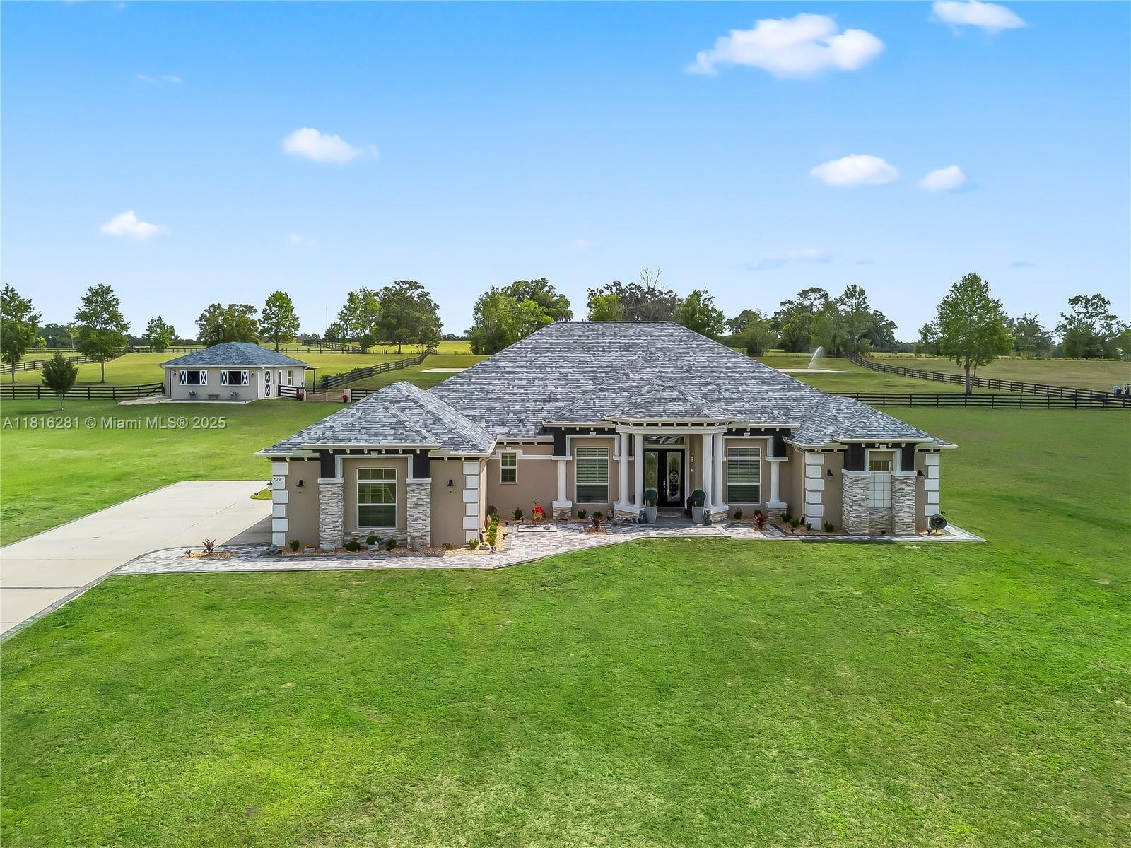 An aerial view shows a single-story house with a gray roof and stone accents — 7161 NE 22nd Ct Rd, Ocala FL 34479, OCALA, FL