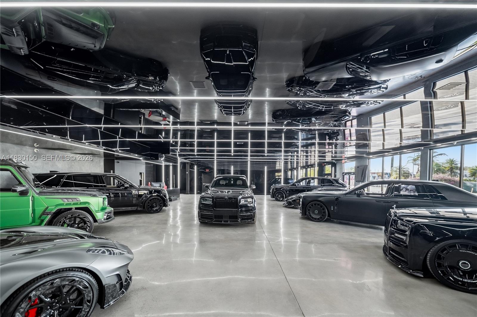 A modern luxury car showroom features polished concrete floors, mirrored ceilings, and linear lighting — 100 NW 36th St, Miami FL 33127, MIAMI, FL