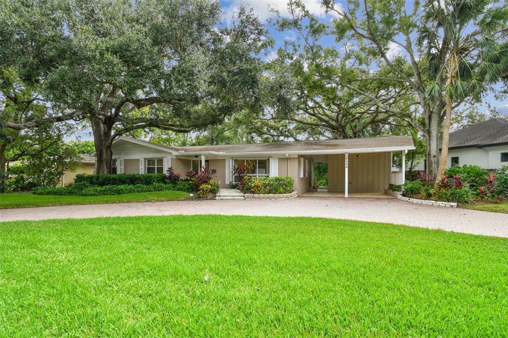 A single-story house with a brick facade, a large front lawn, and a covered carport — 4508 HENDERSON BOULEVARD, TAMPA, FL