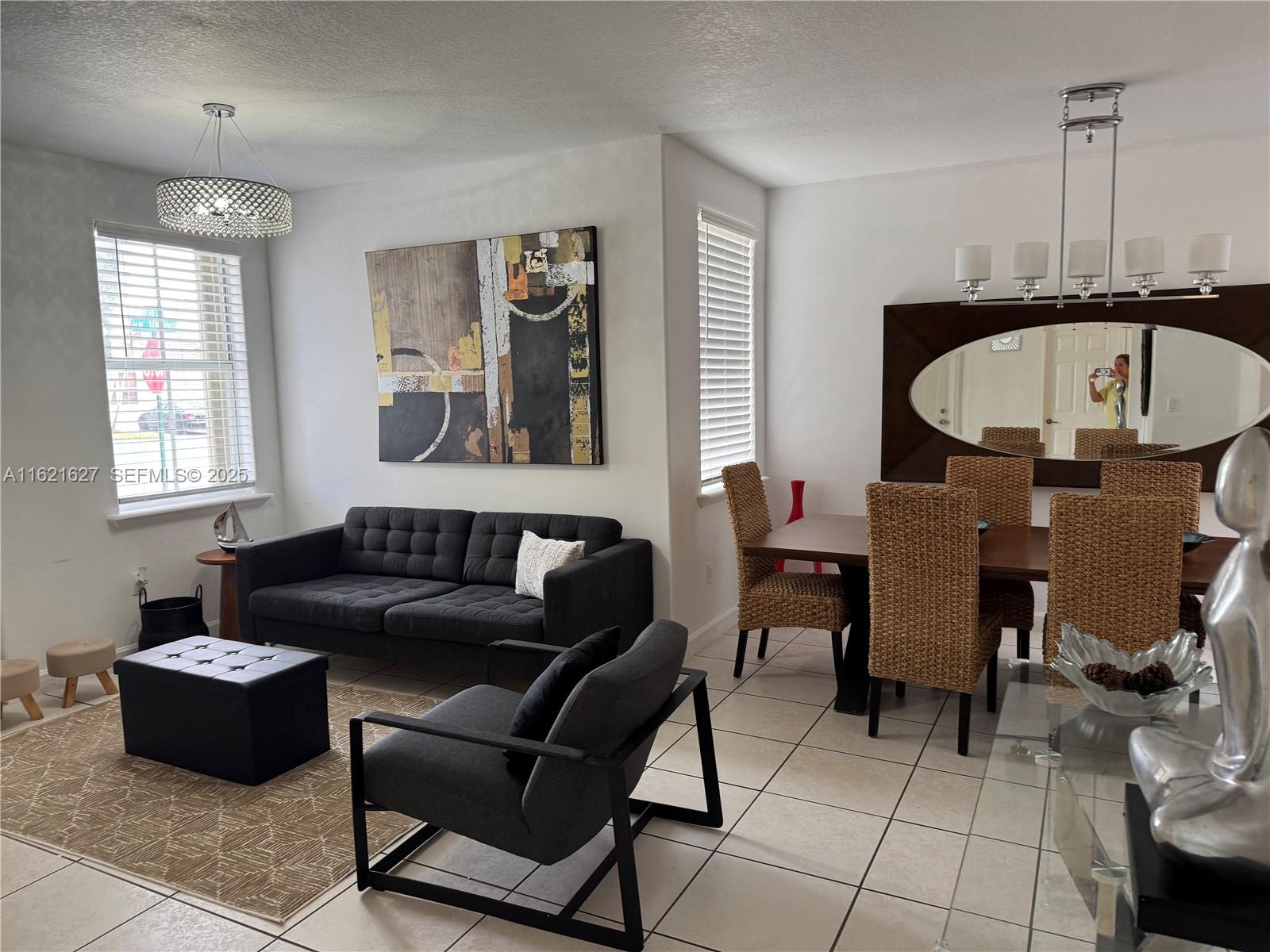 A living room features a gray sofa, a large ottoman, and a framed city skyline print — 4866 NW 108th Psge # 4866, Doral FL 33178, DORAL, FL