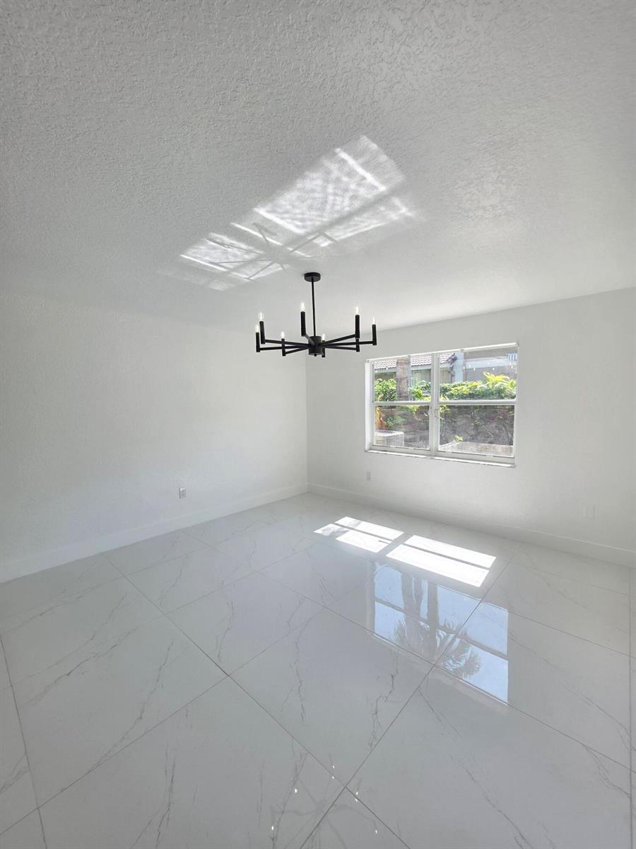 A concrete patio features a covered seating area, a wooden planter box, and a privacy fence — 5466 NW 92nd Avenue, Sunrise FL 33351, SUNRISE, FL