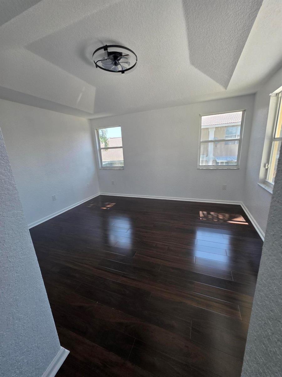 A concrete patio features a covered ceiling fan and a new wooden retaining wall — 5466 NW 92nd Avenue, Sunrise FL 33351, SUNRISE, FL