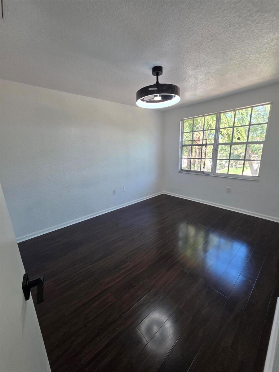 An empty living room features white walls, recessed lighting, and large white marble-patterned floor tiles — 5466 NW 92nd Avenue, Sunrise FL 33351, SUNRISE, FL