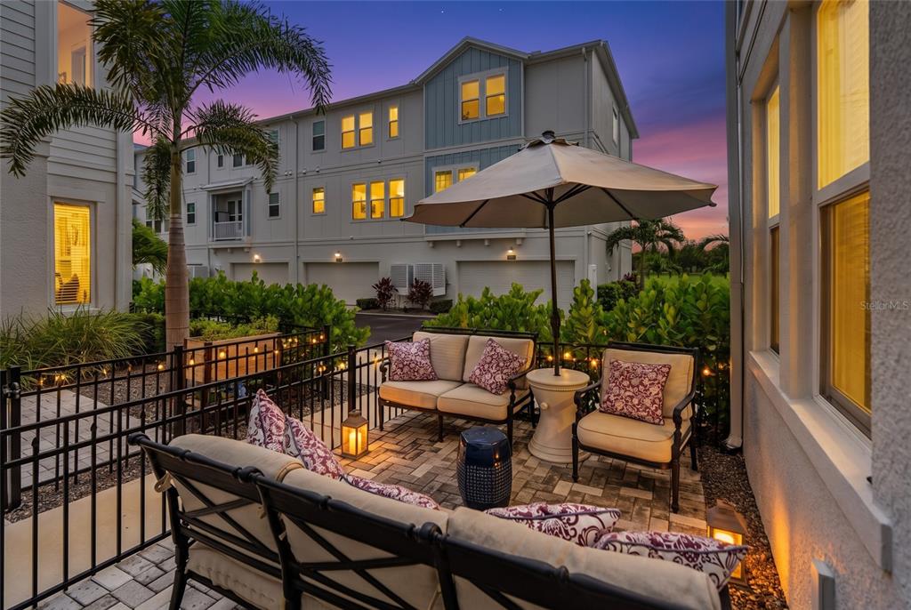 An entryway features a staircase with a gallery wall, light wood flooring, and a console table — 2501 BOONE COURT, SARASOTA, FL
