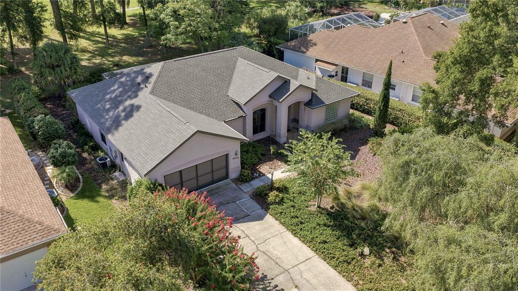 An aerial view shows a single-story house with a gray roof and a concrete driveway — 8939 SW 194TH COURT, DUNNELLON, FL