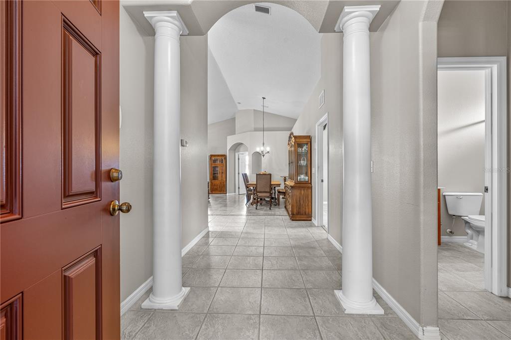 A view from an open doorway into a tiled foyer with two white columns — 511 SAFE HARBOR DRIVE, EDGEWATER, FL