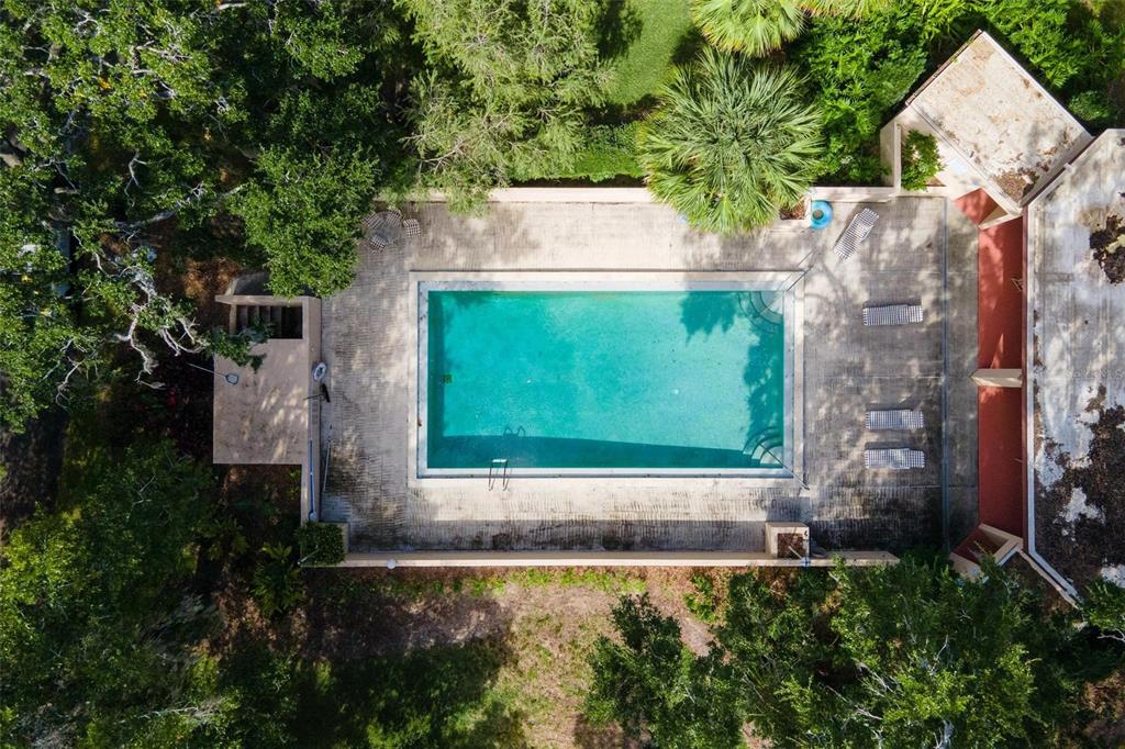 An aerial view shows a rectangular swimming pool surrounded by a concrete deck and trees — 4300 BAYWOOD BOULEVARD UNIT B106, MOUNT DORA, FL