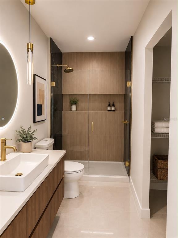 A modern bathroom features a wood-toned vanity, a walk-in shower with glass doors, and tile flooring — 1365 SANDUSKY STREET SE, PALM BAY, FL