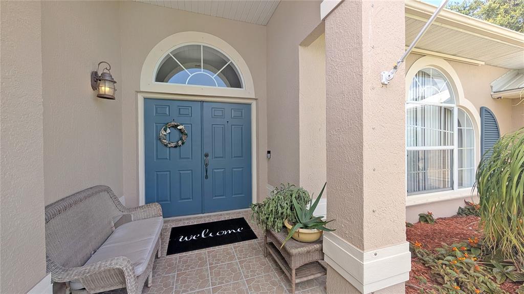 A kitchen with white cabinets, marble-look countertops, and a view of an outdoor pool — 114 N 19TH CIRCLE SW, VERO BEACH, FL