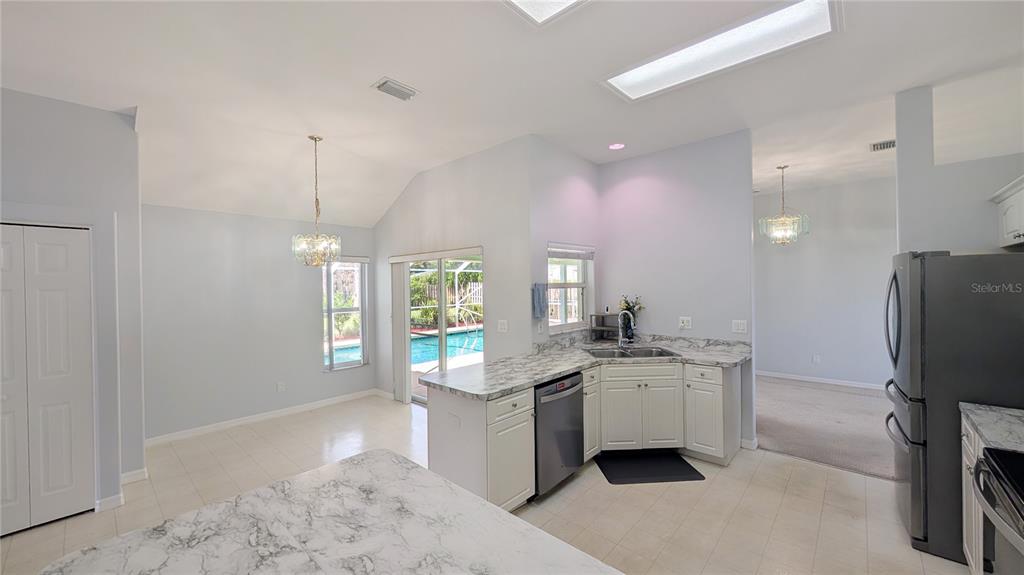 A covered patio features a ceiling fan, a wall-mounted television, and a screened-in swimming pool — 114 N 19TH CIRCLE SW, VERO BEACH, FL