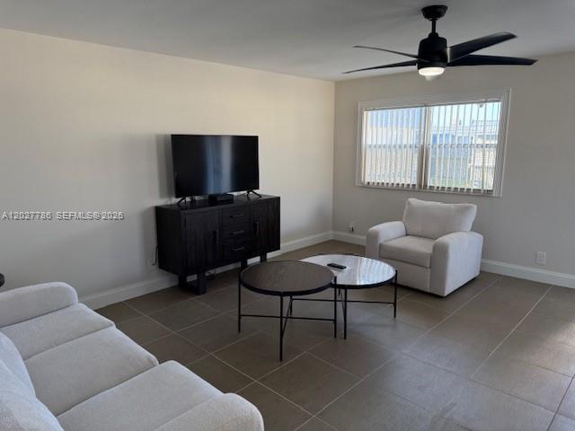 A living room features a white sofa, a dark media console, and a white armchair — 417 Brittany I # 417, Delray Beach FL 33446, DELRAY BEACH, FL