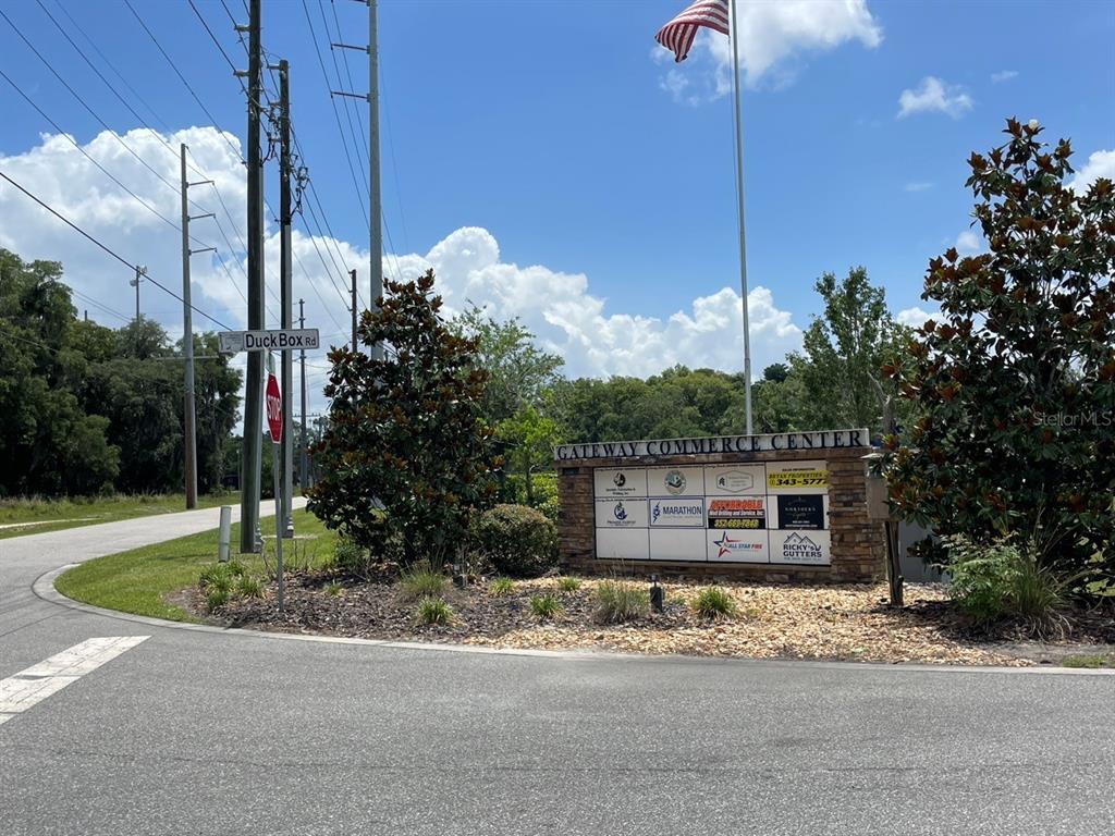 A stone sign for Gateway Commerce Center stands at a road intersection with a stop sign — 1080 DUCK BOX ROAD, UMATILLA, FL