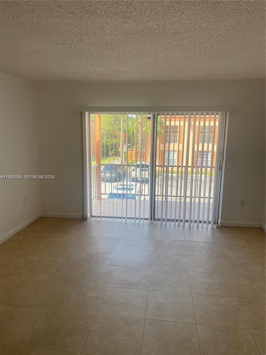 A two-story peach-colored apartment building features a parking lot in the foreground — 7201 Miami Lakes Dr # B14, Miami Lakes FL 33014, MIAMI LAKES, FL