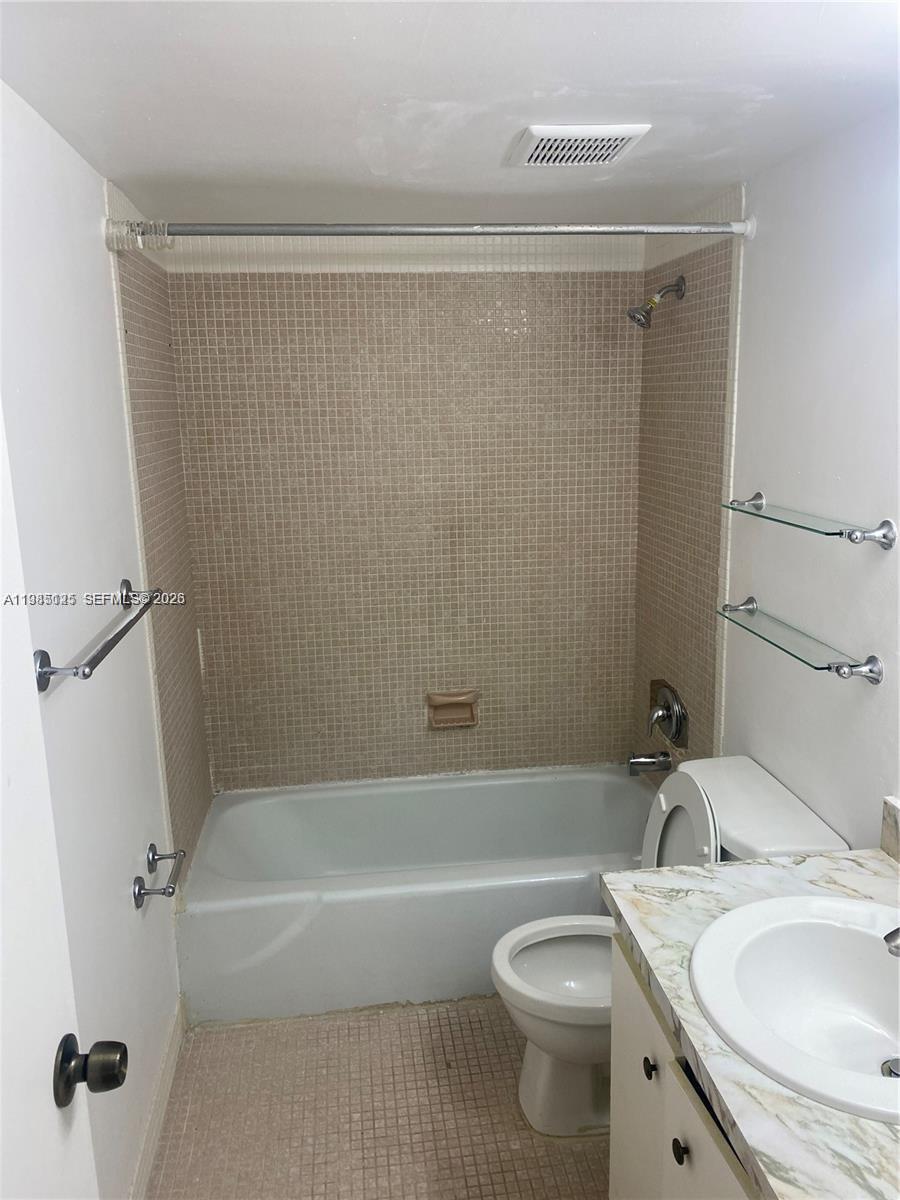An empty room features white walls, beige tile flooring, and a set of louvered closet doors — 7201 Miami Lakes Dr # B14, Miami Lakes FL 33014, MIAMI LAKES, FL