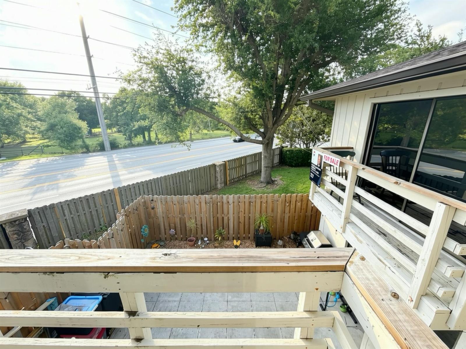 An elevated view of a wooden deck overlooking a fenced yard and a nearby road — 2811 Stoneway Lane # B, Fort Pierce FL 34982, FORT PIERCE, FL