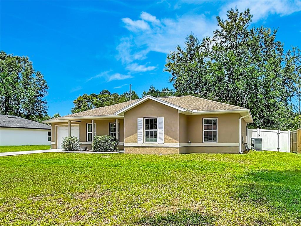 A single-story tan house with a shingled roof and a large front lawn — 3 PINE TRACK PLACE, OCALA, FL