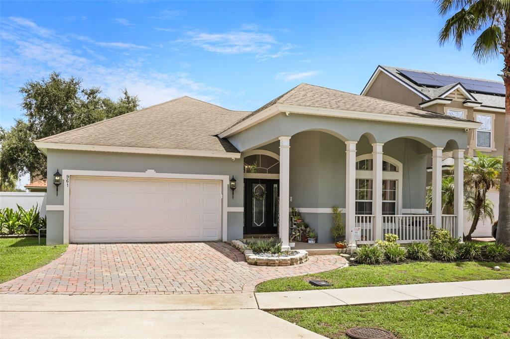 A single-story house with a two-car garage, arched front porch, and a brick paver driveway — 961 MARISA LANE, KISSIMMEE, FL