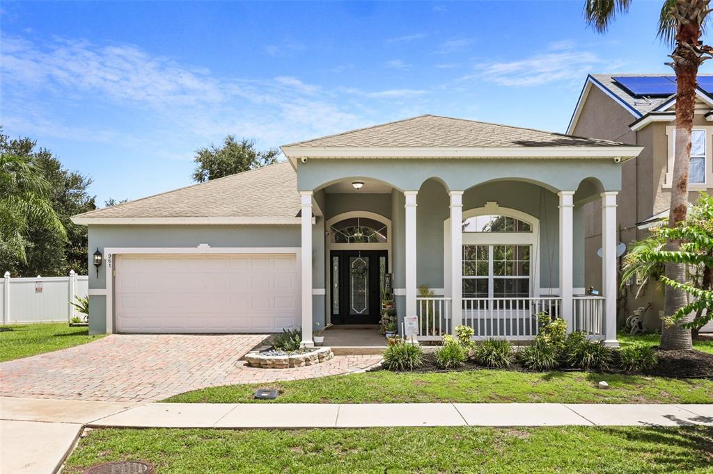 A single-story house with a light blue exterior, a two-car garage, and a front porch — 961 MARISA LANE, KISSIMMEE, FL